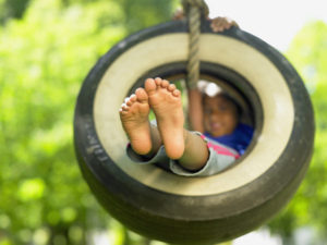 bigstock-Portrait-of-girl-on-tire-swing-47001283