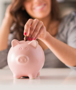 bigstock-Woman-Putting-Coin-In-Piggy-Ba-46096636